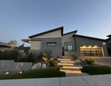 A modern house with steps leading to the front door.