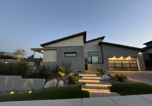 A modern house with steps leading to the front door.