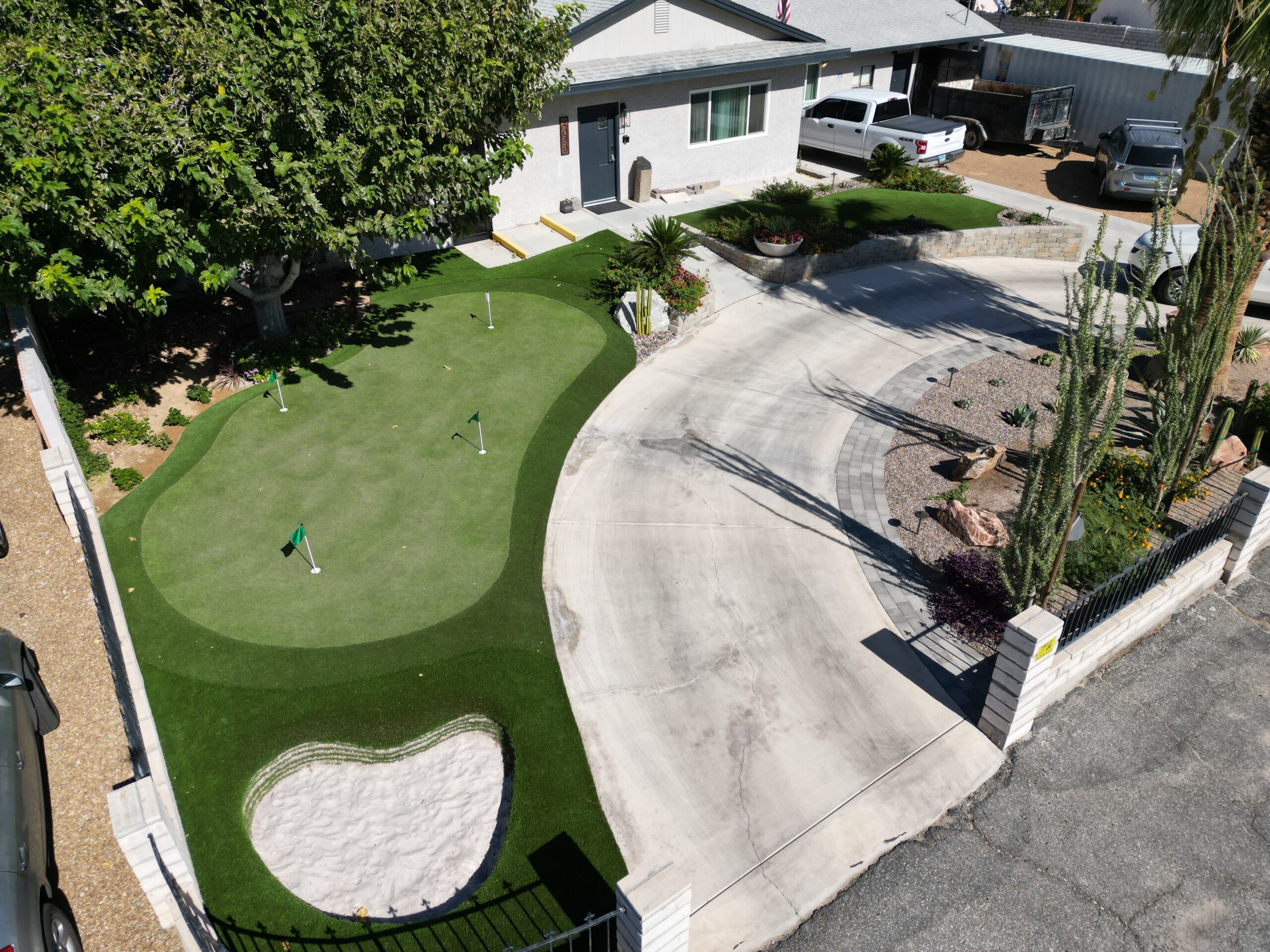 A view of a backyard with a putting green. A view of a backyard with a putting green.
