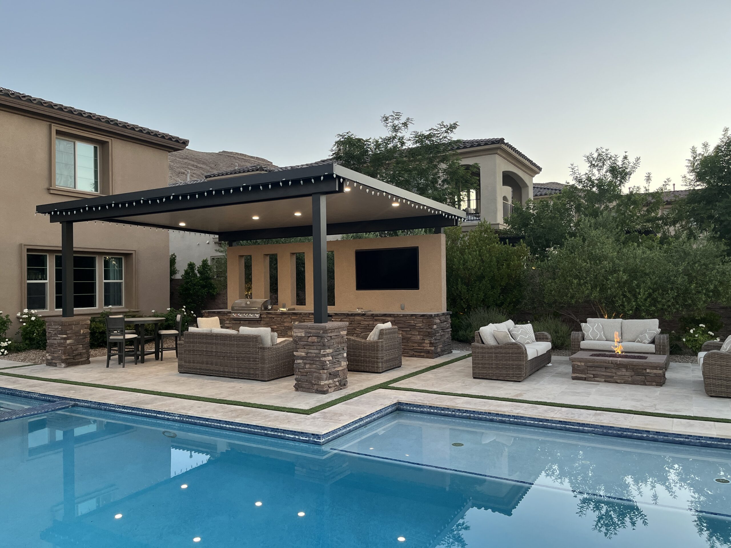 A pool with a covered patio and outdoor furniture.
